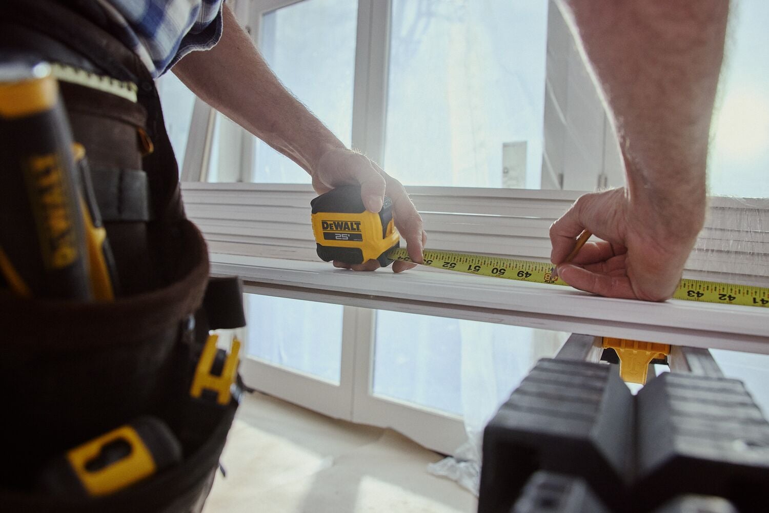 A carpenter uses a tape measure