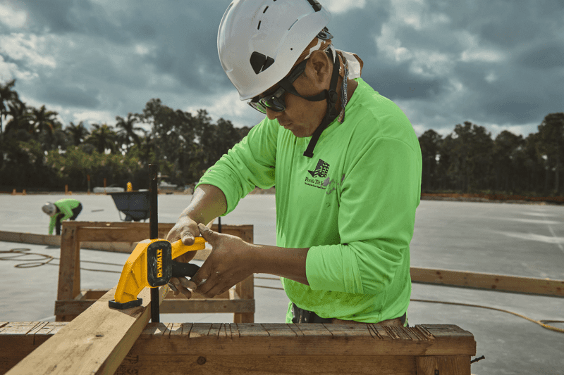 Concrete worker using DEWALT clamp