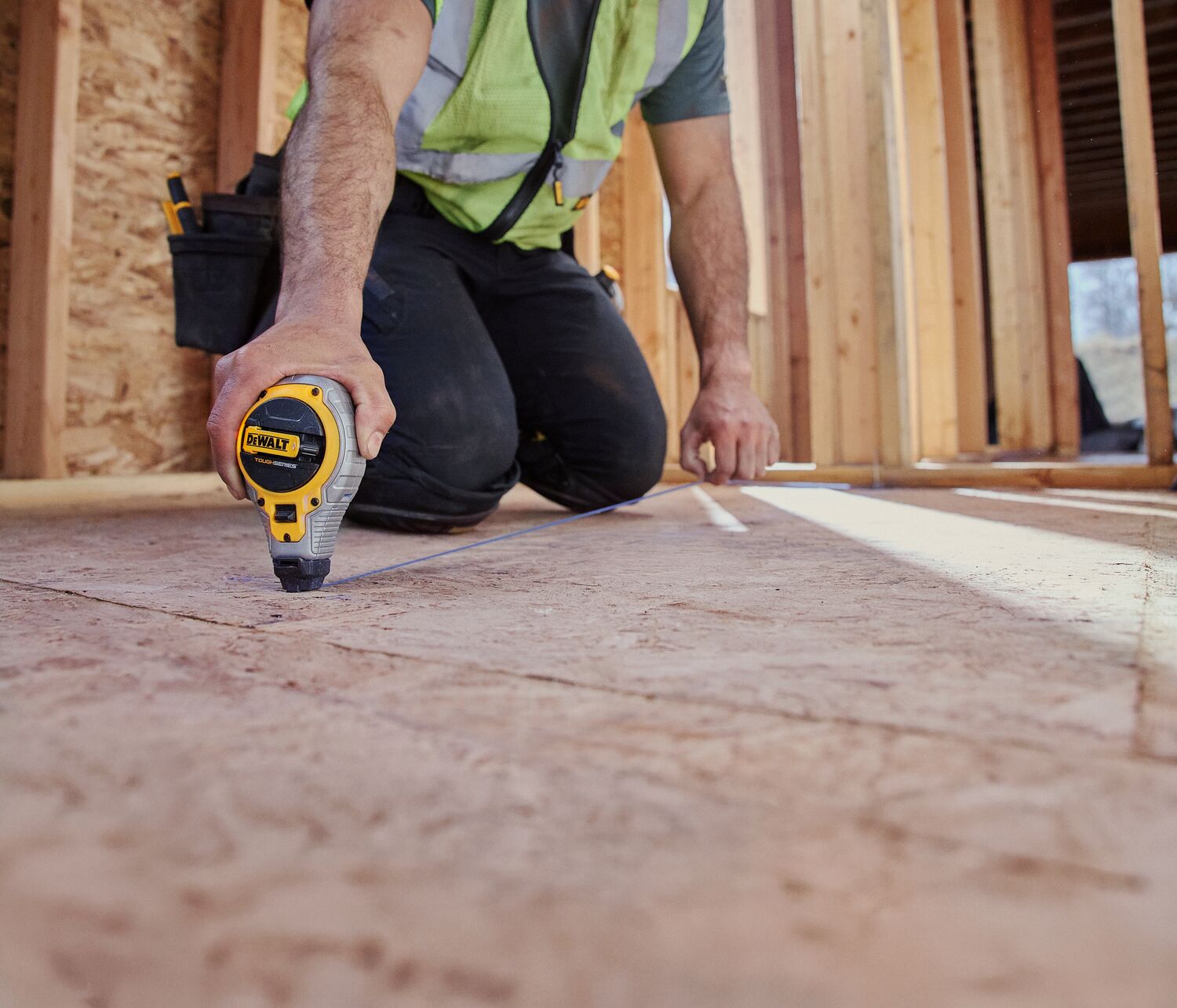 A carpenter uses a nail gun