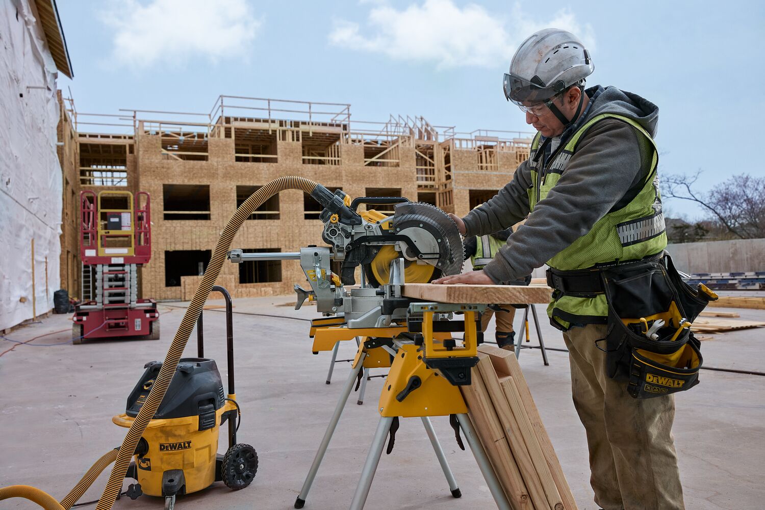 A carpenter uses a miter saw outside on the jobsite