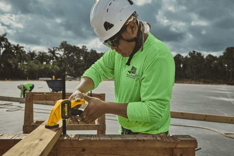 Concrete worker using DEWALT clamp